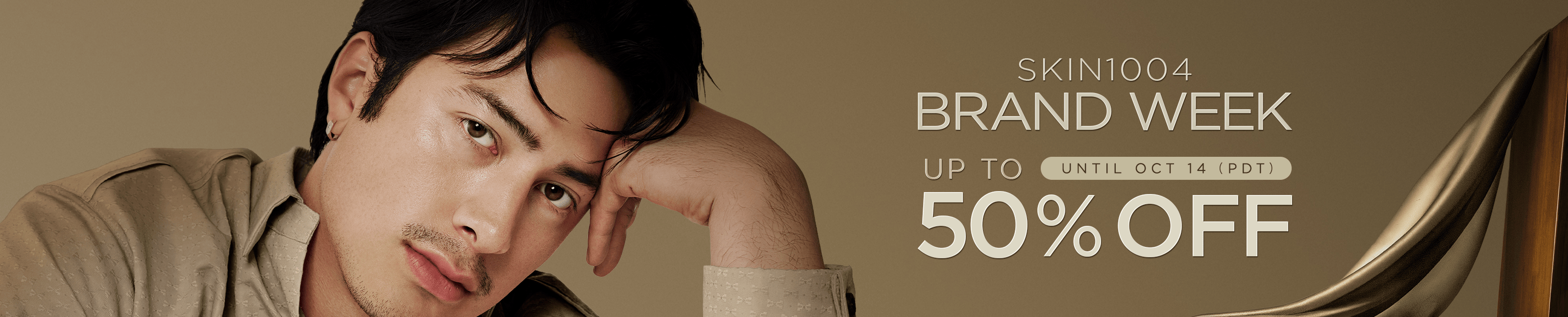 SKIN1004 Brand Week: up to 50% off until October 14 (PDT). A man in a beige shirt rests his head on his hand.